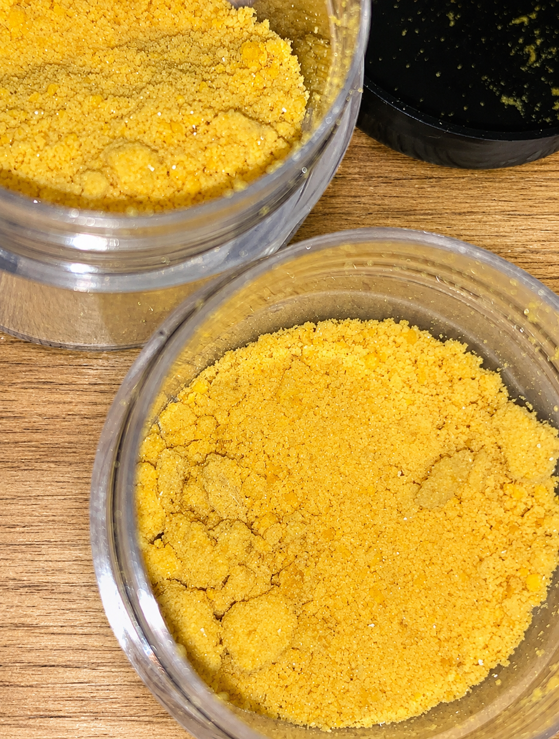 Fine yellow crystalline extract powder inside a clear glass laboratory vial